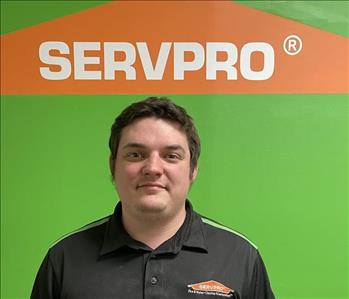 picture of man smiling in front of green SERVPRO wall