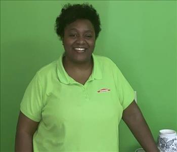 picture of woman smiling in front of green SERVPRO wall