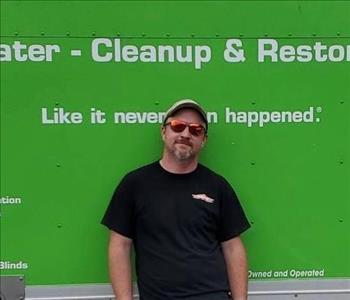 picture of man smiling in front of green SERVPRO truck